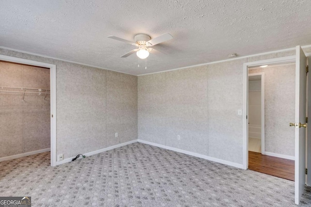 unfurnished bedroom with a ceiling fan, carpet, a closet, and a textured ceiling