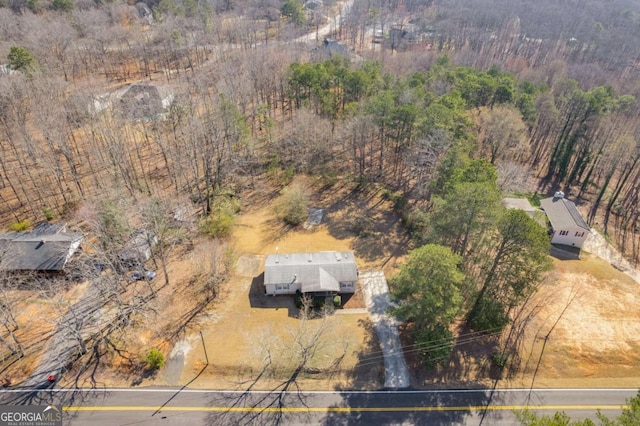 birds eye view of property featuring a wooded view