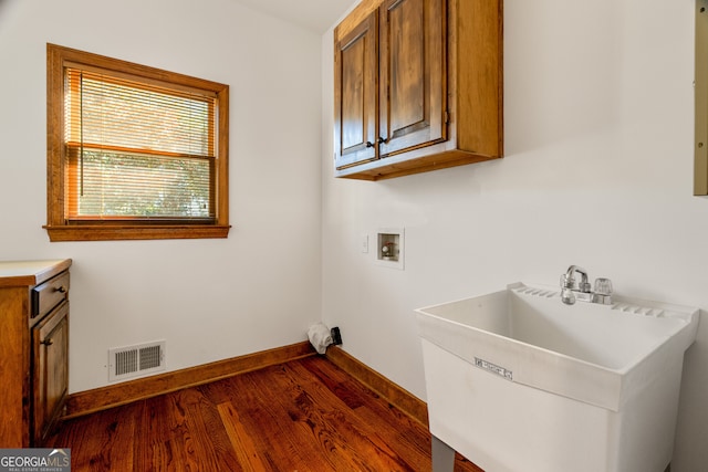 laundry area with visible vents, a sink, dark wood-style floors, baseboards, and hookup for a washing machine