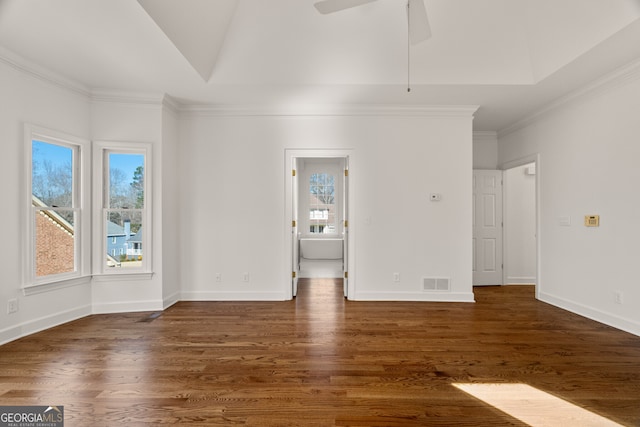 unfurnished room with a tray ceiling, visible vents, and wood finished floors