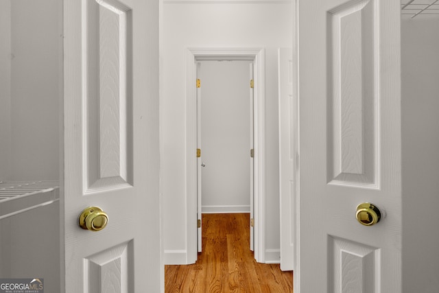 hall with baseboards and light wood finished floors