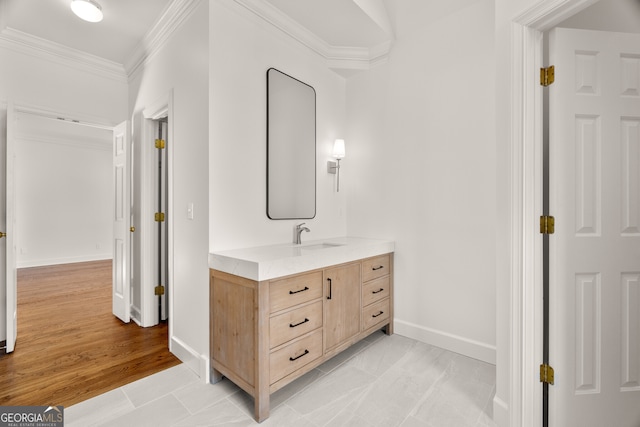 bathroom with vanity, wood finished floors, baseboards, and ornamental molding