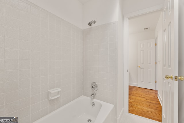 full bath featuring baseboards, wood finished floors, visible vents, and shower / washtub combination