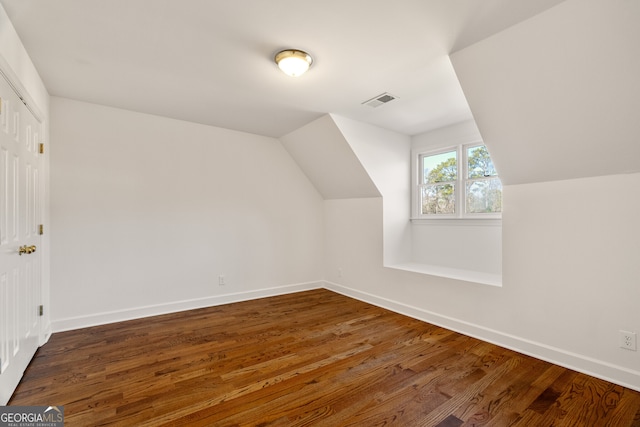 additional living space featuring vaulted ceiling, visible vents, baseboards, and wood finished floors