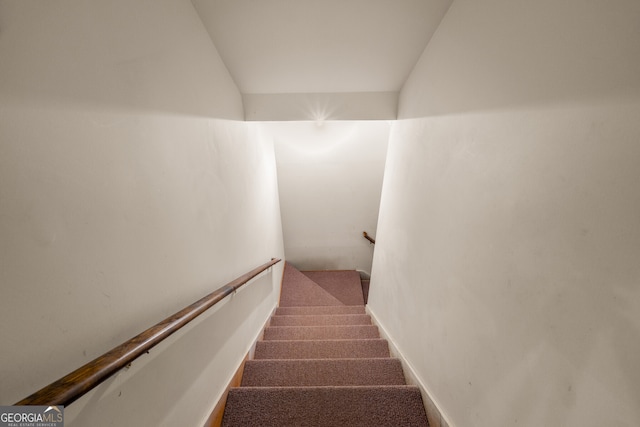 stairs with lofted ceiling and carpet