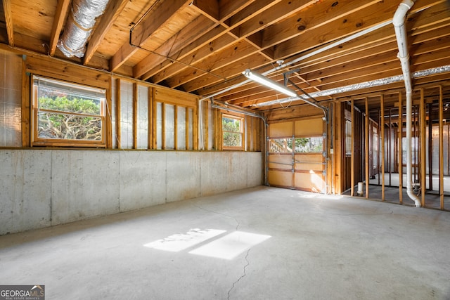 misc room featuring a garage and unfinished concrete flooring