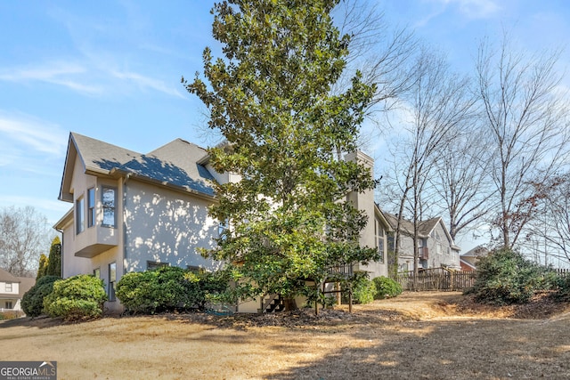 view of property exterior with stucco siding and a chimney