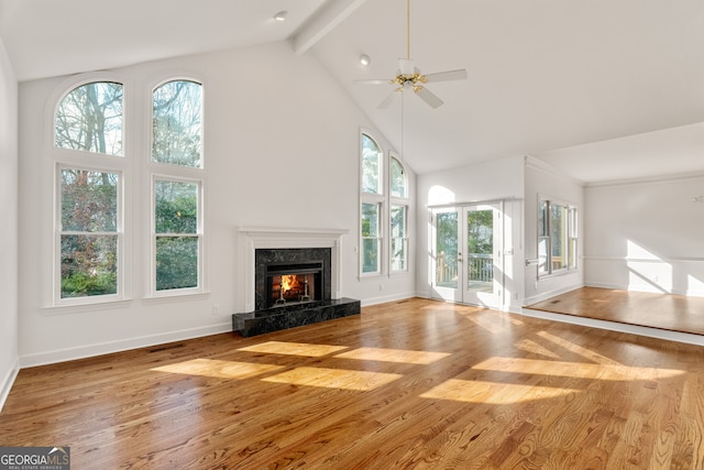 unfurnished living room featuring beamed ceiling, a fireplace, ceiling fan, and wood finished floors