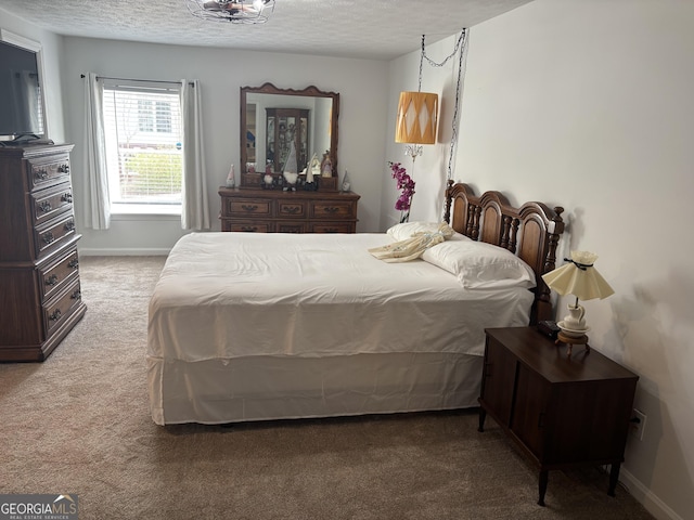 carpeted bedroom with a textured ceiling and baseboards