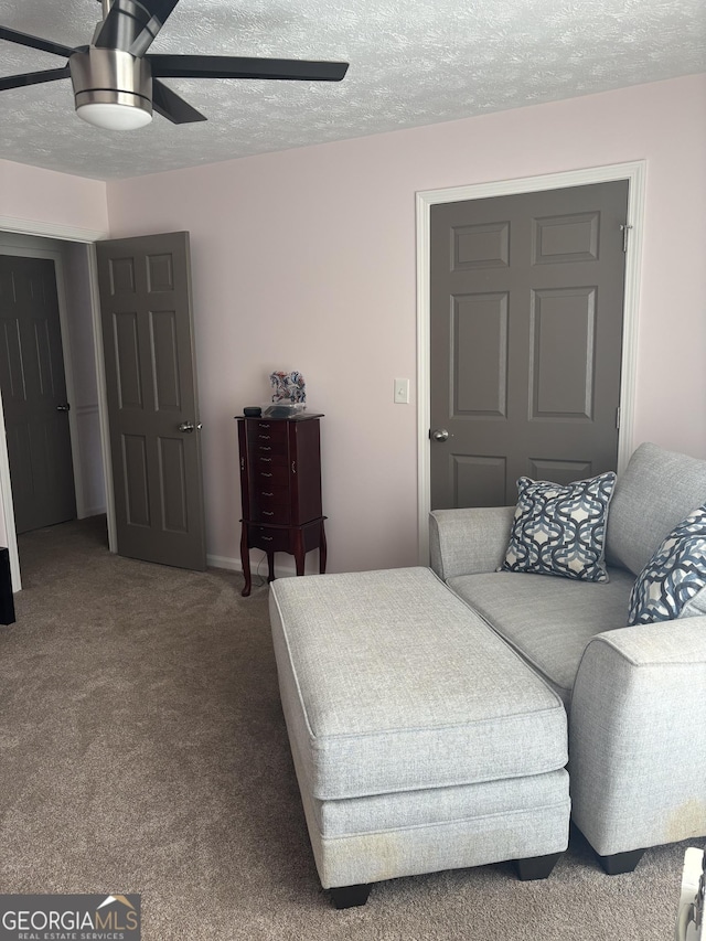 living area featuring carpet flooring, a textured ceiling, and a ceiling fan