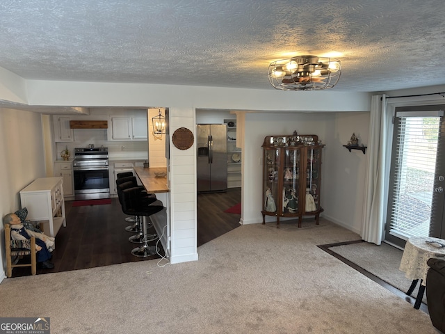 living area with a textured ceiling and dark carpet