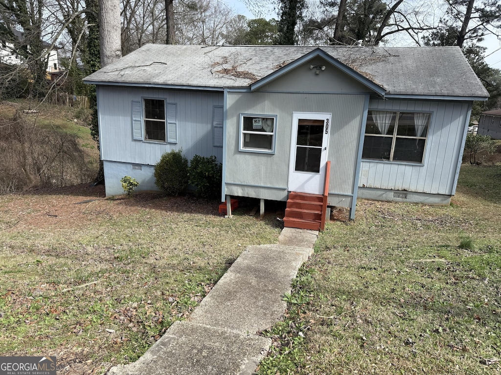 view of front of home featuring crawl space, a shingled roof, a front yard, and entry steps