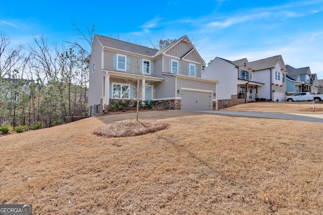 view of front of house with a front yard, fence, driveway, a garage, and board and batten siding