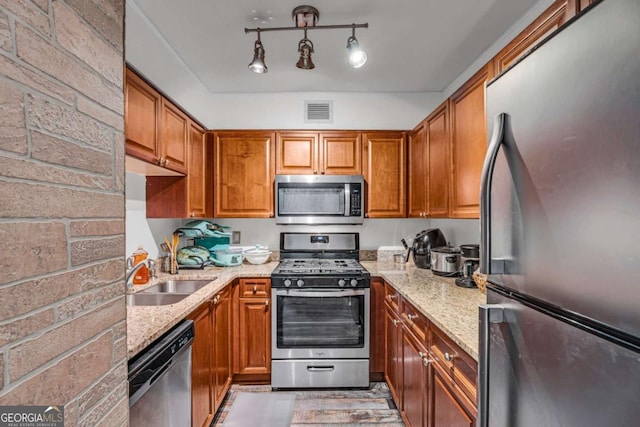 kitchen featuring brown cabinets, stainless steel appliances, and a sink