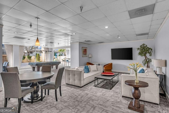 living room with a paneled ceiling and baseboards