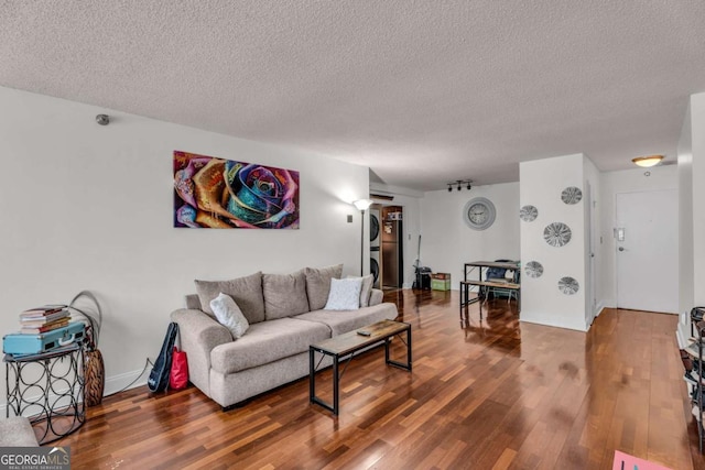 living area featuring a textured ceiling, baseboards, and wood finished floors