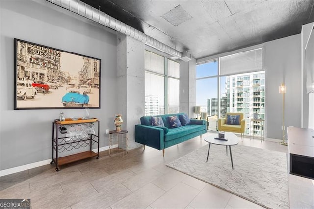 living area featuring a city view, a wall of windows, and baseboards