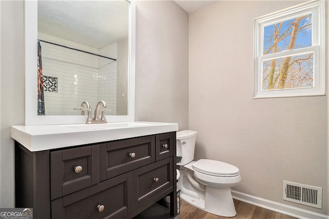 full bath featuring vanity, baseboards, toilet, visible vents, and wood finished floors