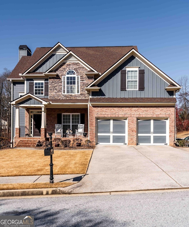 craftsman-style home with a porch, driveway, board and batten siding, and an attached garage