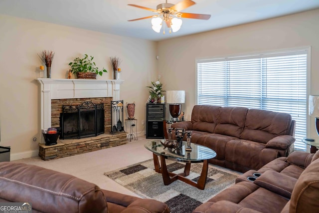 living room featuring a fireplace, baseboards, ceiling fan, and carpet floors