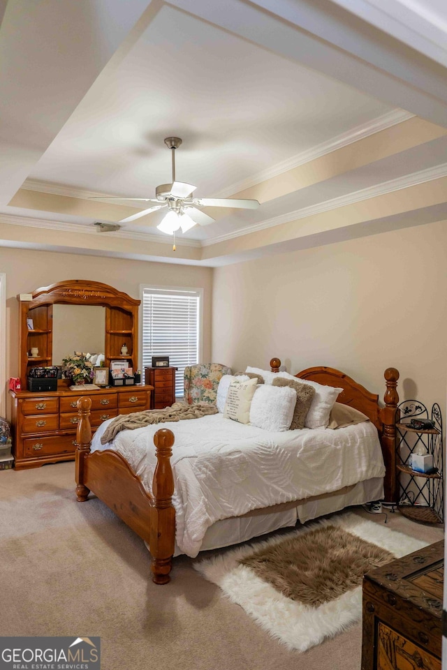 bedroom with light carpet, crown molding, a raised ceiling, and a ceiling fan