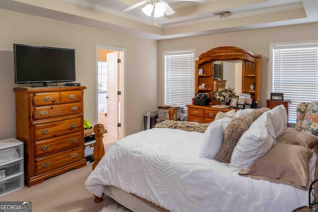 bedroom featuring light carpet, a raised ceiling, a ceiling fan, and ornamental molding