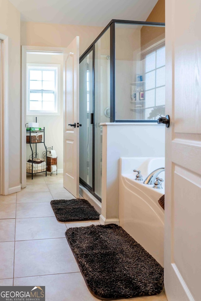 bathroom featuring a garden tub, tile patterned floors, and a shower stall