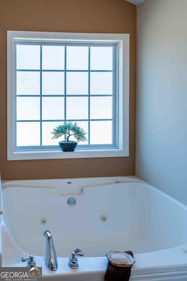 full bathroom featuring a wealth of natural light and a tub with jets