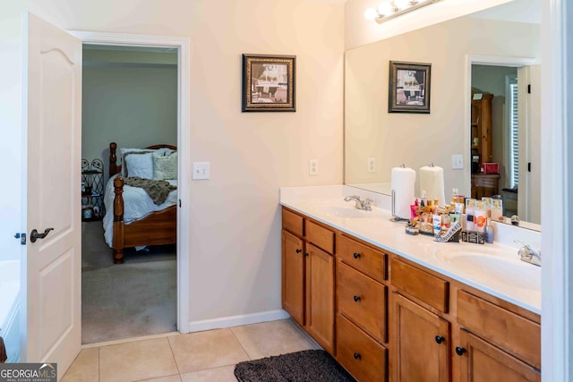 ensuite bathroom featuring tile patterned floors, connected bathroom, double vanity, and a sink