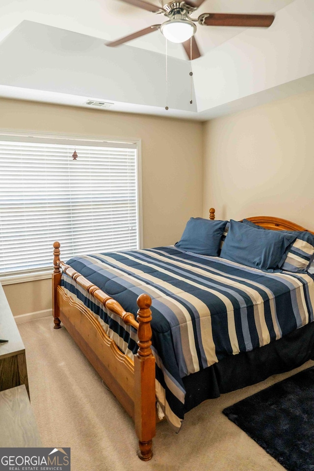 bedroom featuring baseboards, light carpet, visible vents, and a ceiling fan