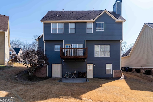 back of property featuring a yard, a chimney, and a patio area