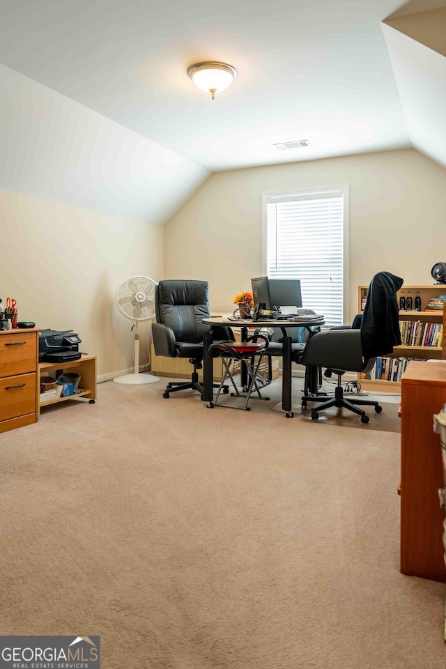 office space featuring visible vents, carpet floors, and vaulted ceiling