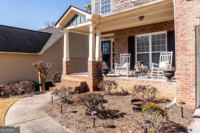 property entrance with brick siding and covered porch