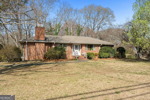 single story home featuring brick siding, a chimney, and a front lawn