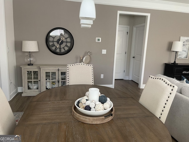 dining space with baseboards and wood finished floors