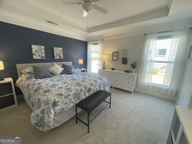 bedroom with a raised ceiling, crown molding, and visible vents