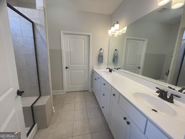 bathroom with double vanity, visible vents, a stall shower, and a sink