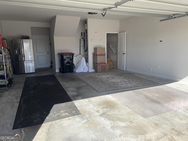 garage featuring stainless steel fridge and a garage door opener