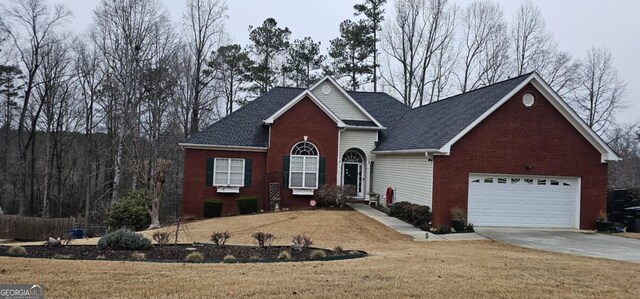 traditional home with brick siding, a garage, driveway, and a front yard