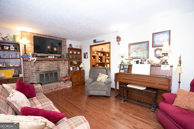 1972 Cox Dr, Austell, GA 30168 - living area featuring a textured ceiling, a brick fireplace, and wood finished floors