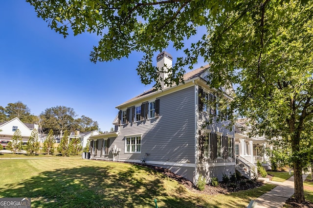 view of property exterior featuring a yard and a chimney