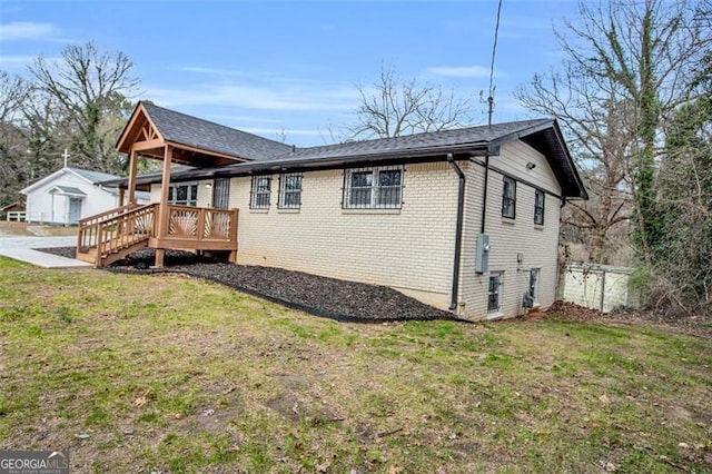 exterior space with fence, a lawn, brick siding, and a wooden deck