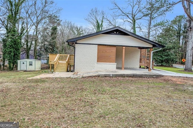 view of front of home with brick siding, an attached carport, a front lawn, an outdoor structure, and a storage unit