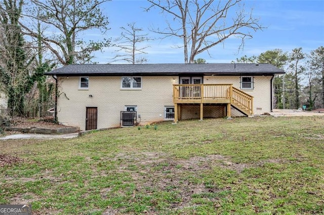 back of property featuring a deck, stairs, a lawn, and brick siding