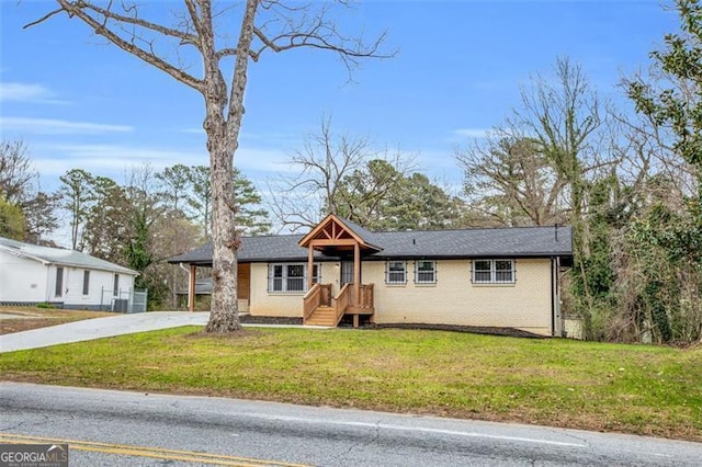 ranch-style house featuring a front lawn, brick siding, and driveway