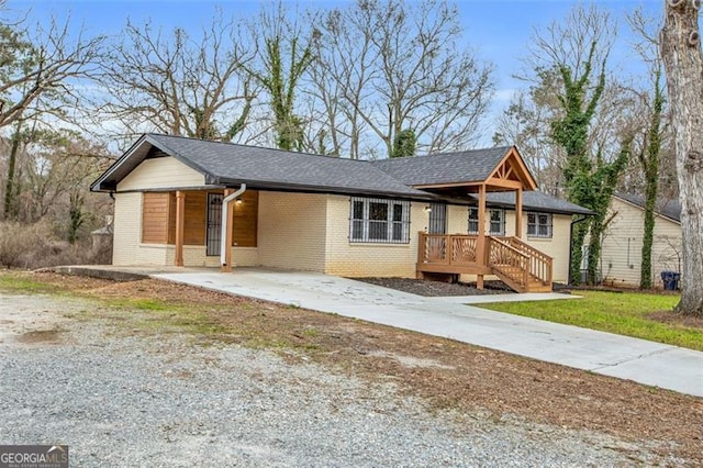 single story home with brick siding, driveway, a front lawn, and a carport