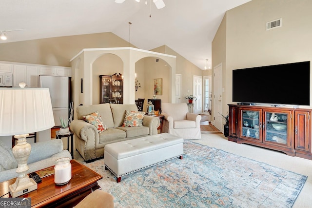 living room featuring visible vents, light carpet, high vaulted ceiling, arched walkways, and ceiling fan