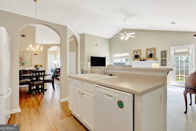 kitchen featuring visible vents, arched walkways, a sink, dishwasher, and open floor plan