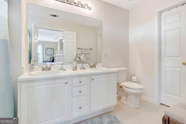 ensuite bathroom with double vanity, connected bathroom, visible vents, and a sink