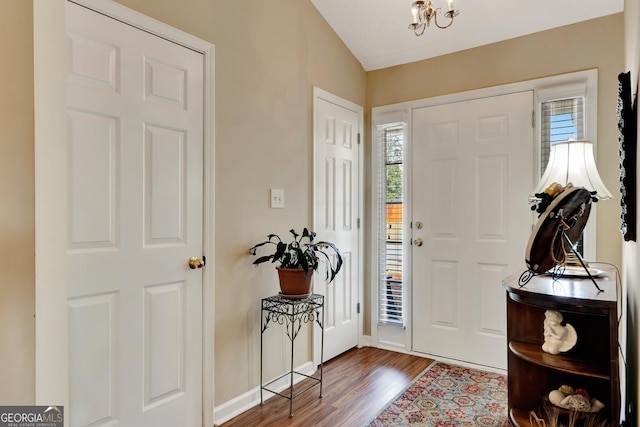 entryway featuring a notable chandelier, wood finished floors, and baseboards